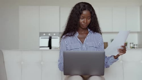 Young african businesswoman working remotely from home office with laptop