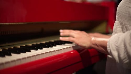 Close up of woman playing a red piano