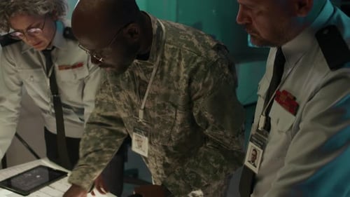 Black Male Lieutenant Briefing Superiors on Enemy Positions in Command Center