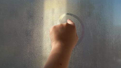 Hand Draws Smiley Face on Foggy Glass