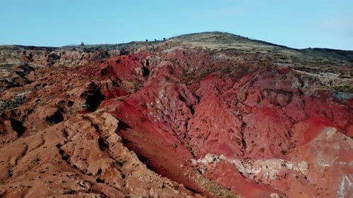 Aerial Steep Red Rocky Cliff with Erosion Lines Picturesque Scattered Boulders