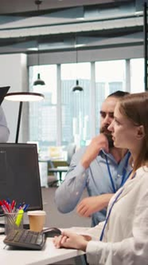 Coworkers Collaborate at Computer in Modern Office