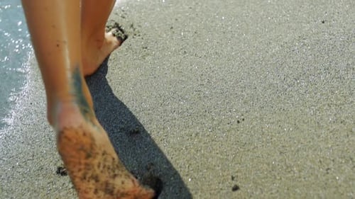 Woman feet walking stepping on the sand at the beach. by the sea.