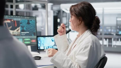 Scientist Working in Research Lab with Microscope