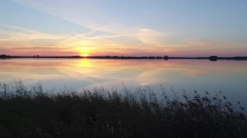Aerial Over the Lake at Sunset Soft Sunset Skies Reflections on Calm Water Surface Stunning Summer