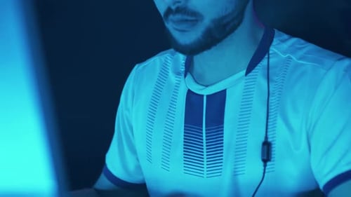 Gamer Wearing Headphones Concentrates on Computer