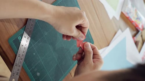 Hands tear apart heart shape paper into little pieces