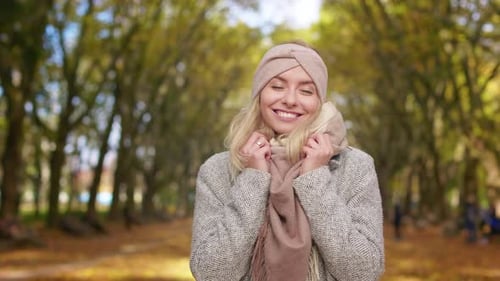 Attractive Blonde Woman Standing Posing in Park in Autumn