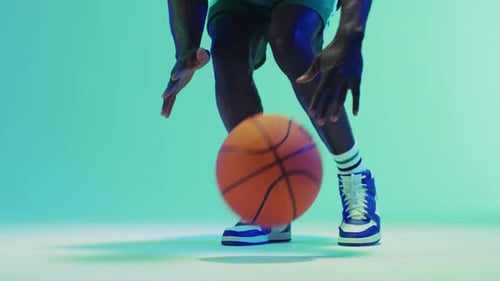 Video des unteren Abschnitts eines afroamerikanischen männlichen Basketballspielers, der auf blauem Hintergrund einen Ball hüpft