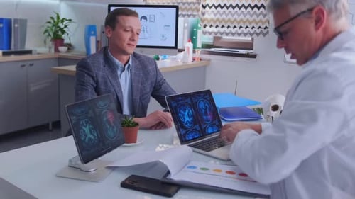 Doctor Shows Brain MRI Results to Patient in Modern Medical Office