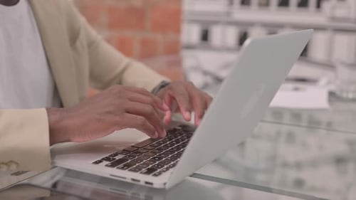 Close Up of African Man Typing on Laptop