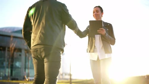 Man and Woman Stand on Nature Landscape in Sun Rays and Shake Hands As Sign of Greeting or Respect
