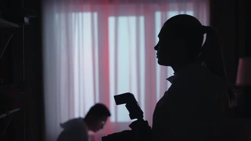 Silhouettes of Investigators in Dimly Lit Room