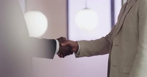 4k video footage of two unrecognizable businessmen shaking hands in an office