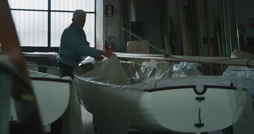 Câmera lenta do mestre sênior da tradição antiga, veleiro, a construção manual de pequenos barcos está funcionando