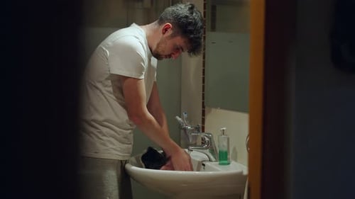 Man Giving Bath to His Guinea Pig on Bathroom Sink at Home