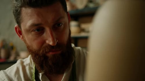 Man Creating Pottery in Brightly Lit Workshop