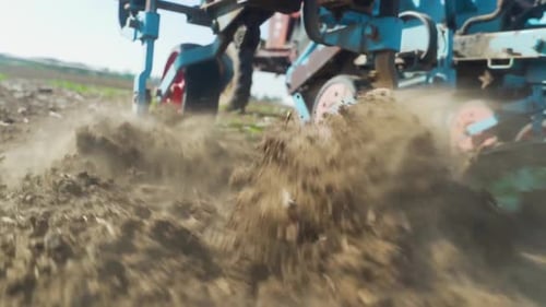 Slow Motion CLOSE UP tracking shot: A close-up of a part of an agricultural is Notched in the ground
