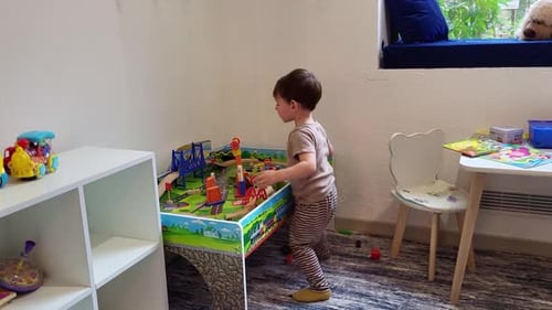 Child Plays With Toy Train Set Indoors