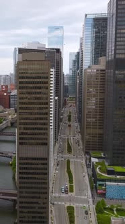 Chicago River with numerous bridges over. Drone rising along the beautiful buildings above the river