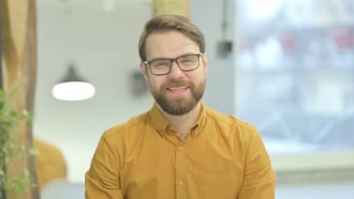 Man with Beard Waving and Talking Indoors