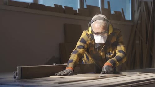 Adult Cutting Wood in Workshop with Table Saw