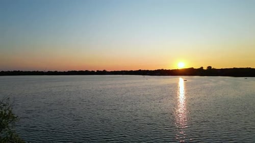 Friedliche, ruhige und entspannende malerische Sonnenuntergangsreflexionen auf dem Wasser an warmen Sommerabenden medit