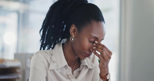 Stressed Woman Massaging Bridge of Nose at Work