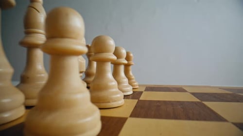 Closeup First Chess Move in Logic Game Man Fingers Playing with White Figures