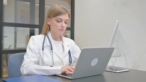 Female Doctor Typing on Laptop in Clinic