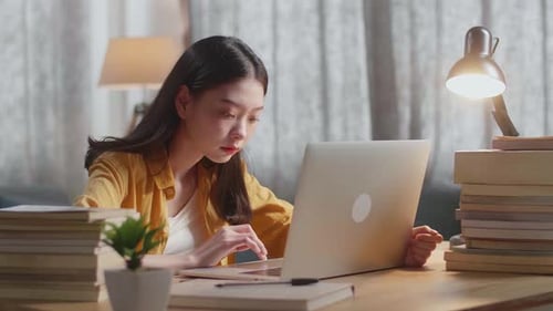 Young Woman Studying at Home with Laptop