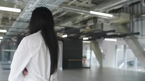 Businesswoman walks away in modern office in slow motion leaving her work behind