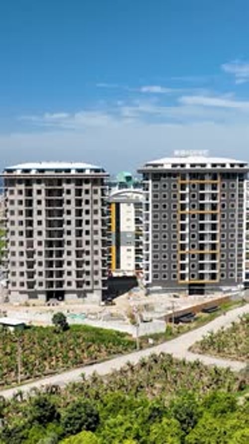 Vídeo vertical: perspectiva aérea de una obra de construcción de gran altura que construye rascacielos desde arriba