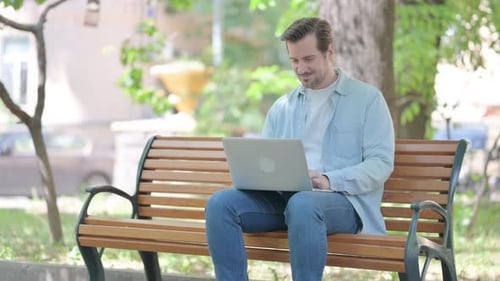 Man Works on Laptop, Celebrates Good News