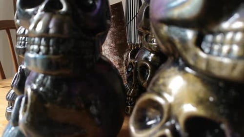 Colourful painted ceramic spooky death skull totem crafts pottery ornament closeup dolly left shallo