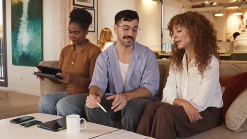 Diverse Creative Team Collaborating on Project Document in Modern Office
