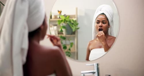 El cuidado bucal, la higiene y la mujer cepillándose los dientes en el baño de casa para una rutina matutina de bienestar