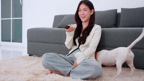 Young Woman Plays with Dogs on Rug