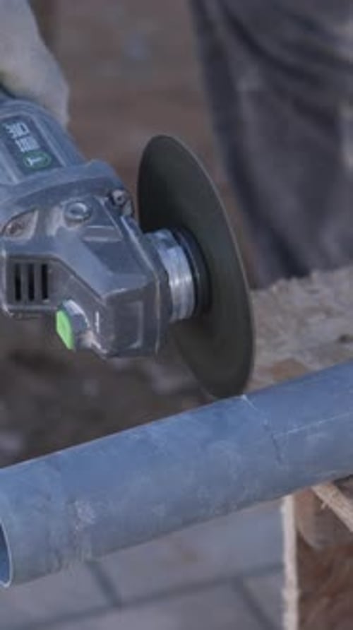 Plumber Precisely Shapes Pipe During Outdoor Installation Task Skilled Worker Meticulously Slices