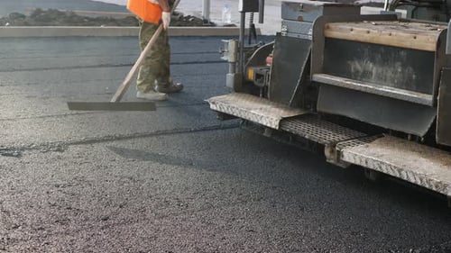 An Asphalt Spreader or an Asphalt Paver Machine on a Road Construction Site