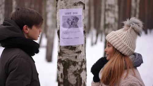 Side View Anxious Caucasian Teenage Couple Standing in Winter Park Looking for Lost Pet