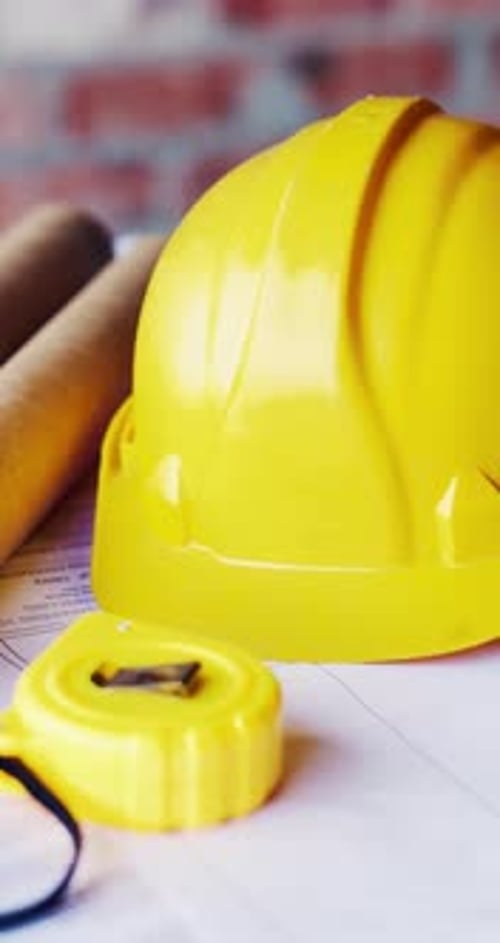 Helmet, architecture and blueprint on table with safety documents, construction or building design