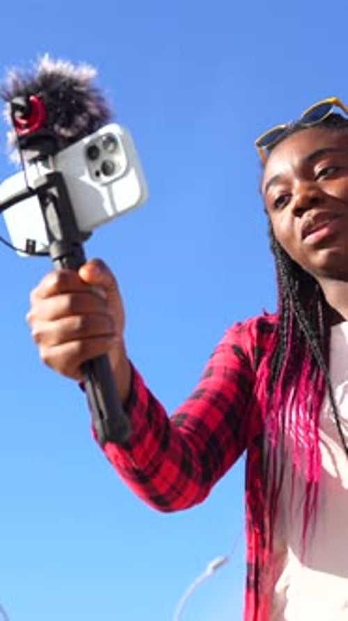 Woman Recording Vlog with Phone and Microphone Outdoors