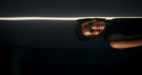 Young adult fashion model smiles in dark studio