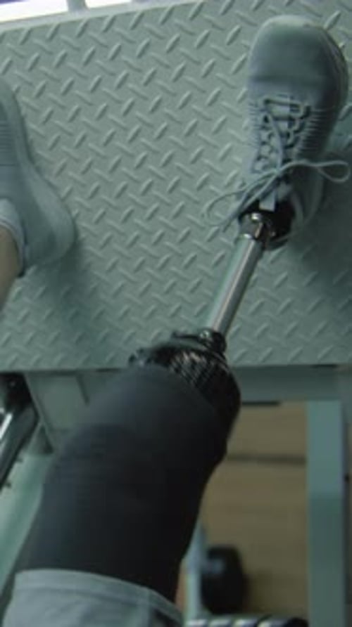 Sportsman with Prosthetic Leg Trains on Leg Press Machine in Gym