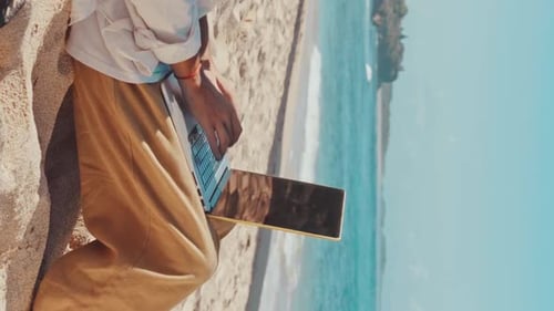 Close Up of Hands of Man Freelancer Typing on Laptop Sits on Beach Near Sea