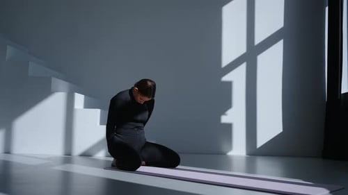 Fitness Workout In Studio Sportswoman In Black Sportswear Sitting On Floor And Stretching In Room