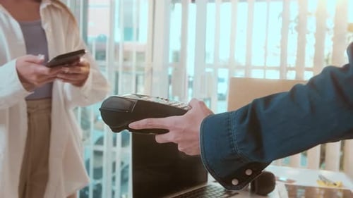 woman customer using QR code payment via smartphone for paying at shop