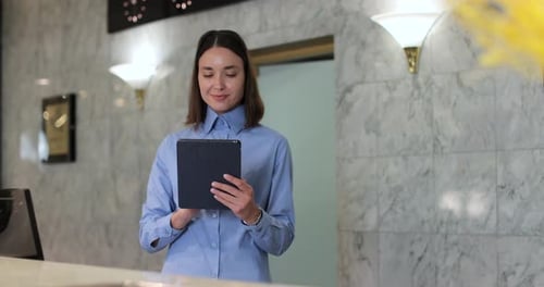 Receptionist Hotel or Woman with Tablet in Lobby for Booking Schedule Check in App or Reservation