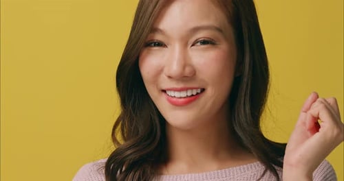 Smiling Young Woman Points at Cheek